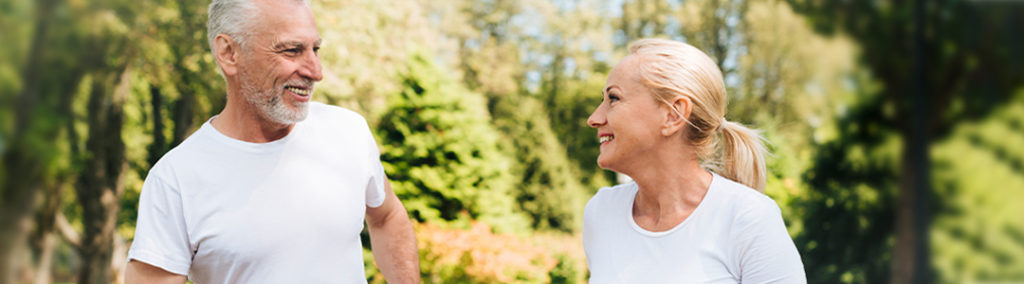 elderly man and woman jogging and smiling